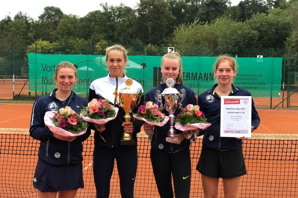 Vier Tennisspielerinnen stehen auf einem Tennisplatz und halten Pokale sowie Blumenarrangements in den H&auml;nden.