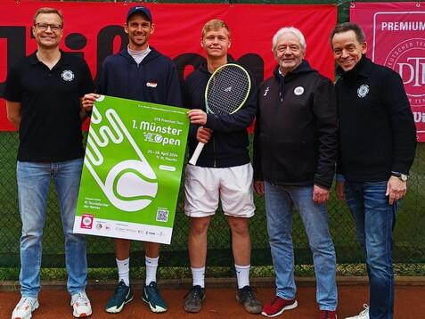 F&uuml;nf Personen stehen auf einem Tennisplatz mit einem Plakat f&uuml;r das 1. M&uuml;nster Open in der Hand.