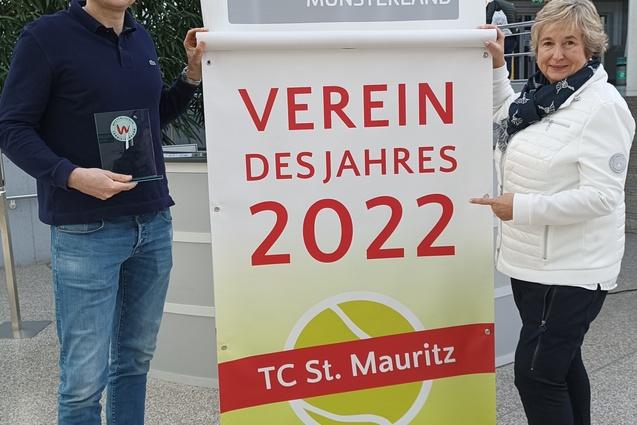Zwei Personen pr&auml;sentieren ein Banner mit der Aufschrift &bdquo;Verein des Jahres 2022&ldquo; des TC St. Mauritz in einem Foyer.